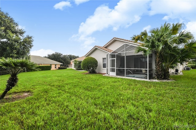 back of property with a sunroom and a lawn