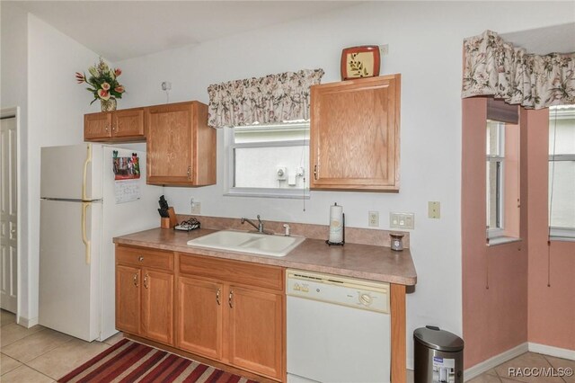 916 W Skyview Crossing Dr, Hernando, FL 34442 - kitchen with white appliances, a sink, light tile patterned floors, and brown cabinets