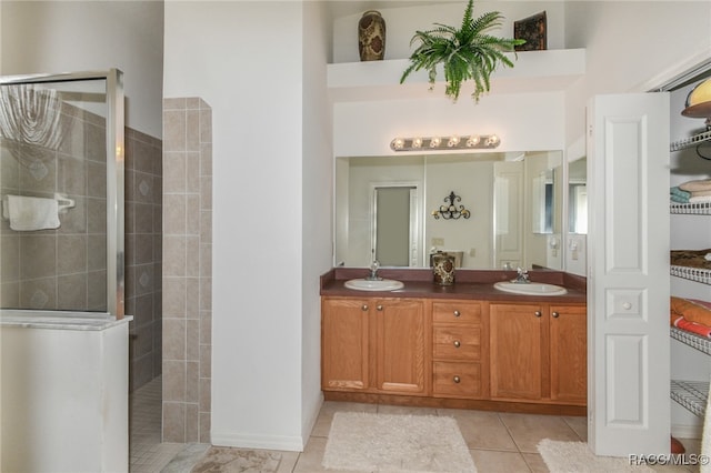 bathroom featuring tiled shower, vanity, and tile patterned floors