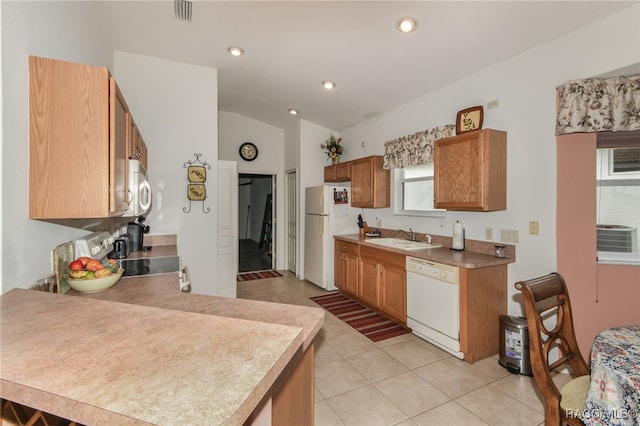 kitchen featuring lofted ceiling, white appliances, sink, and light tile patterned floors