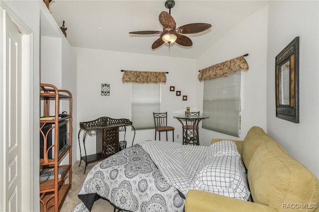 carpeted bedroom with ceiling fan and vaulted ceiling