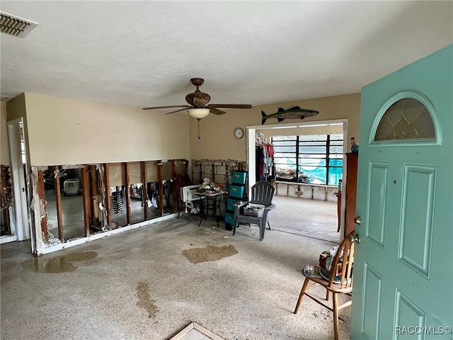 interior space with a textured ceiling and ceiling fan