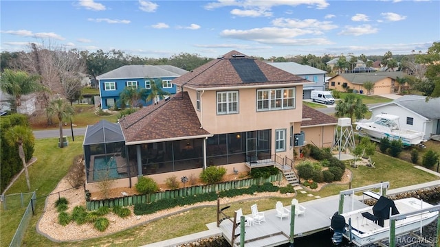 rear view of property with glass enclosure and a sunroom