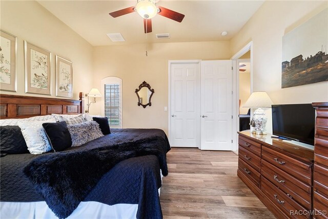 bedroom with ceiling fan, light hardwood / wood-style floors, and a closet