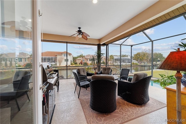 sunroom / solarium featuring ceiling fan and a water view