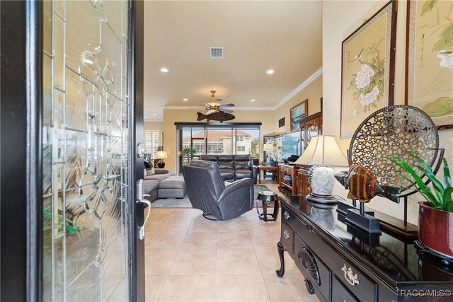 tiled living room featuring ceiling fan and ornamental molding