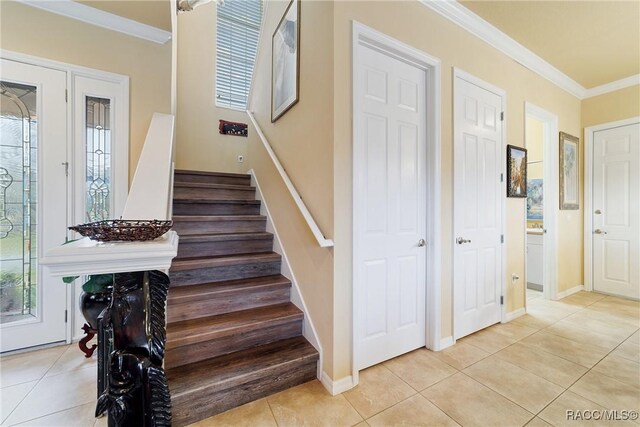 stairs with ornamental molding and tile patterned floors