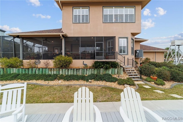 back of property featuring a lawn, ceiling fan, cooling unit, a sunroom, and a patio area