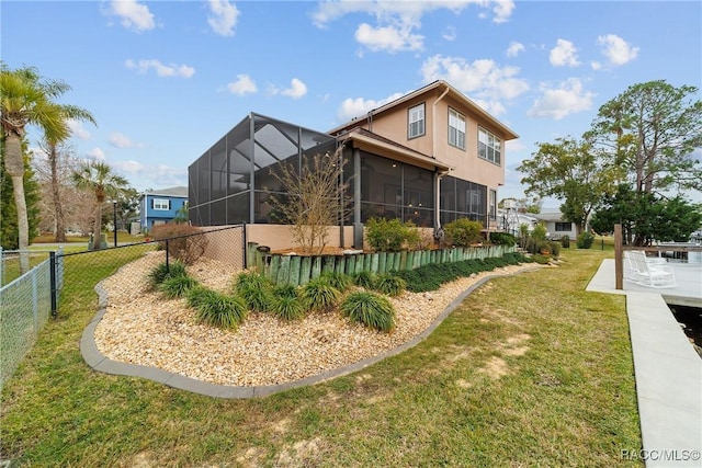 rear view of property with a sunroom and a lawn