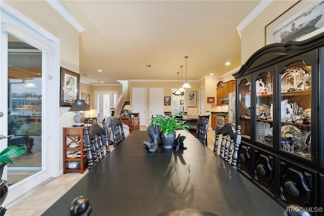 dining room with crown molding and light tile patterned flooring