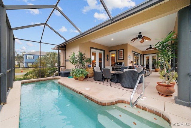 view of swimming pool with french doors, ceiling fan, glass enclosure, and a patio