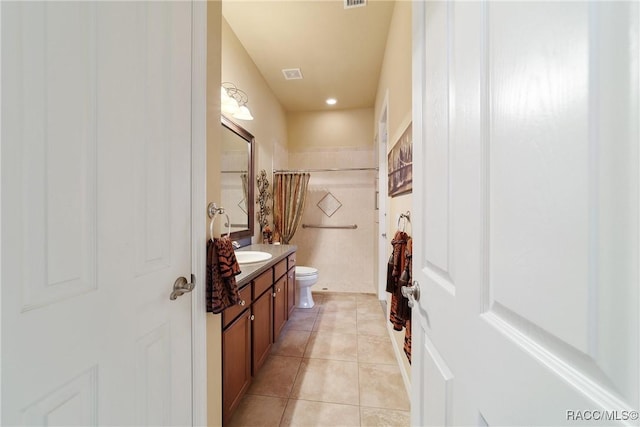 bathroom with a shower with shower curtain, vanity, tile patterned floors, and toilet