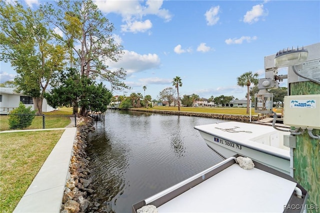 dock area with a water view and a lawn