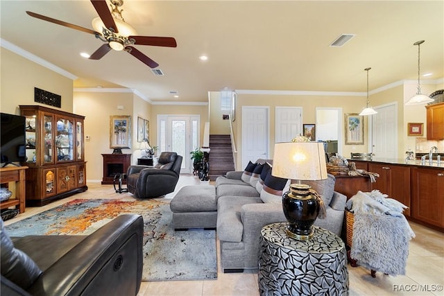 tiled living room with sink, ceiling fan, and crown molding