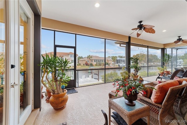 sunroom / solarium featuring ceiling fan, plenty of natural light, and a water view