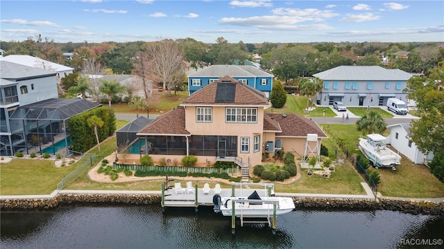 back of house featuring glass enclosure and a water view