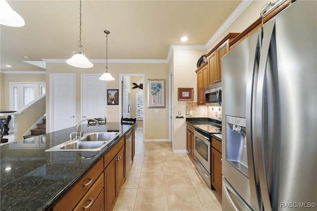 kitchen featuring stainless steel appliances, sink, dark stone countertops, light tile patterned floors, and hanging light fixtures