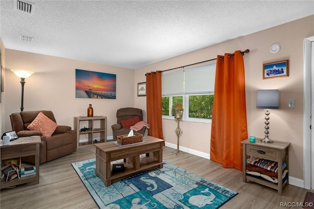 10038 62nd Ter N Unit 2, Saint Petersburg, FL 33708 - living area with a textured ceiling, light wood finished floors, and baseboards