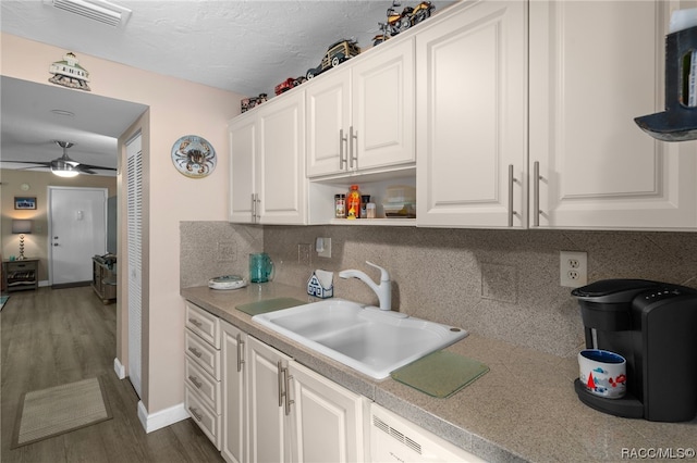 kitchen featuring sink, ceiling fan, decorative backsplash, dark hardwood / wood-style flooring, and white cabinetry