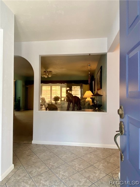 tiled entryway featuring ceiling fan