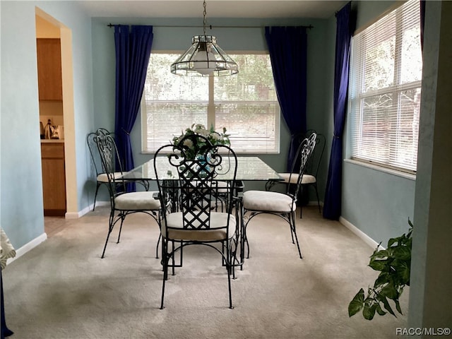 carpeted dining room with a notable chandelier