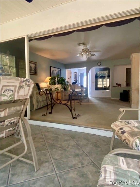 interior space with tile patterned floors and ceiling fan