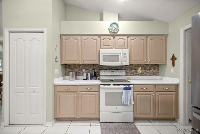 2 Nancy Pkwy, Yankeetown, FL 34498 - kitchen with white appliances, vaulted ceiling, light tile patterned flooring, tasteful backsplash, and light countertops