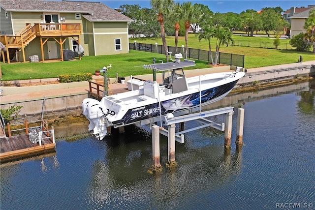 dock area featuring a lawn and a deck with water view