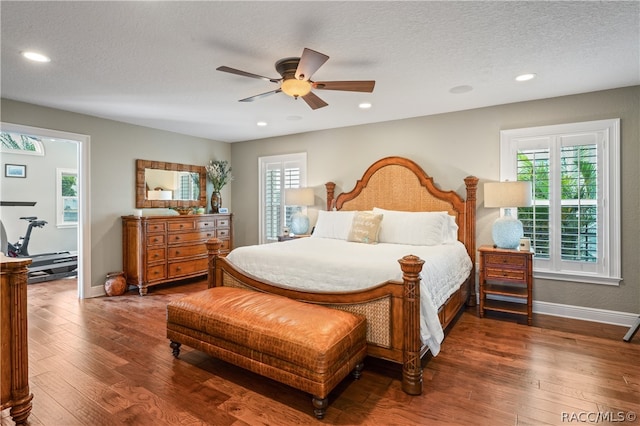 bedroom with ceiling fan, dark hardwood / wood-style flooring, and a textured ceiling