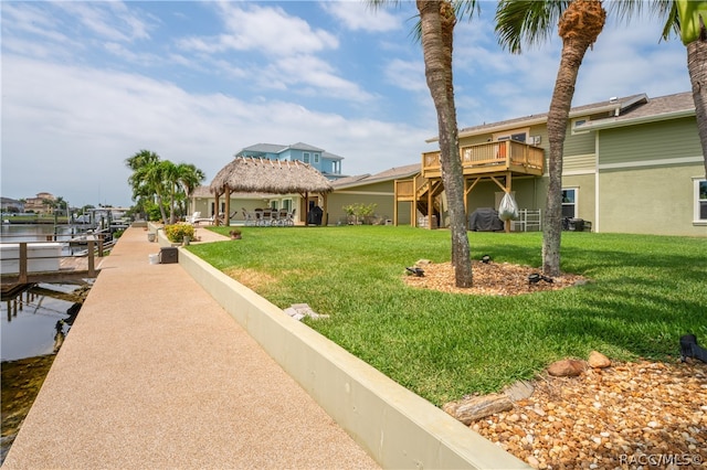 view of property's community with a lawn, a boat dock, and a wooden deck