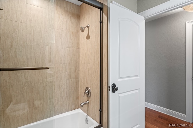 bathroom with hardwood / wood-style floors and tiled shower / bath combo