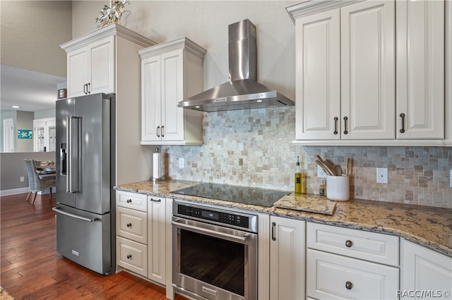 kitchen featuring dark hardwood / wood-style floors, white cabinetry, stainless steel appliances, and wall chimney range hood