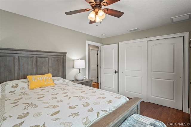 bedroom with ceiling fan, dark wood-type flooring, and a closet