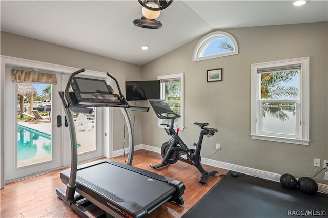 exercise area featuring light hardwood / wood-style flooring and lofted ceiling