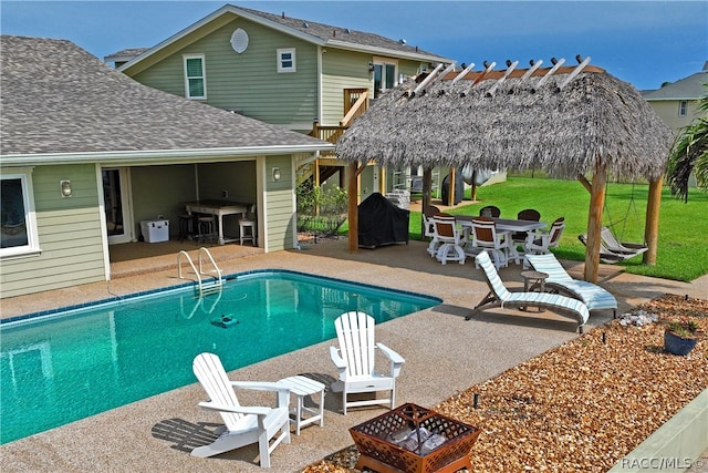 view of pool featuring a lawn, a patio, and a fire pit