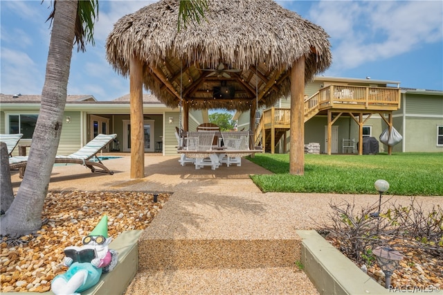 back of property featuring a gazebo, a patio, a yard, and a wooden deck