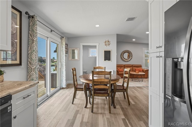 dining room with light hardwood / wood-style floors and vaulted ceiling