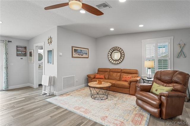 living room with light wood-type flooring and ceiling fan