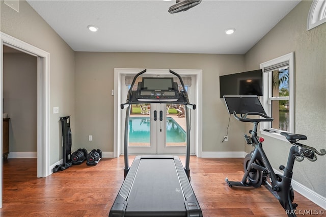 workout room featuring plenty of natural light, french doors, and hardwood / wood-style flooring