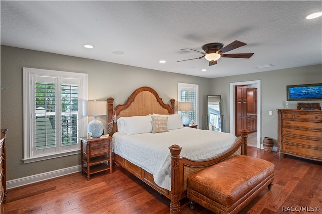 bedroom featuring ceiling fan, dark wood-type flooring, and a textured ceiling