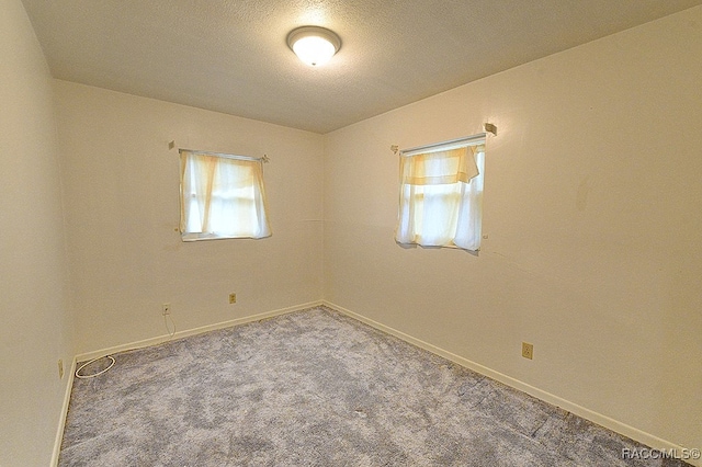 carpeted spare room with a textured ceiling