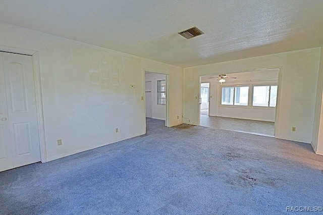 carpeted empty room with a textured ceiling