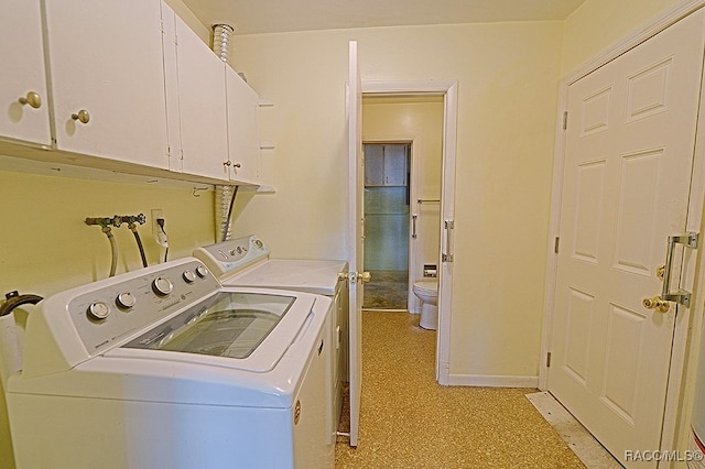 washroom with washing machine and dryer and cabinets