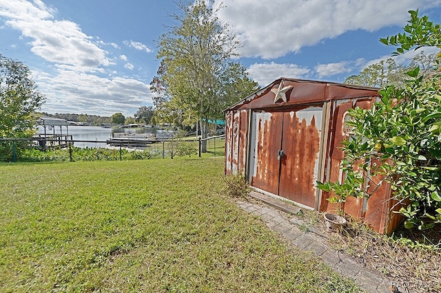 view of yard featuring a water view and a storage unit