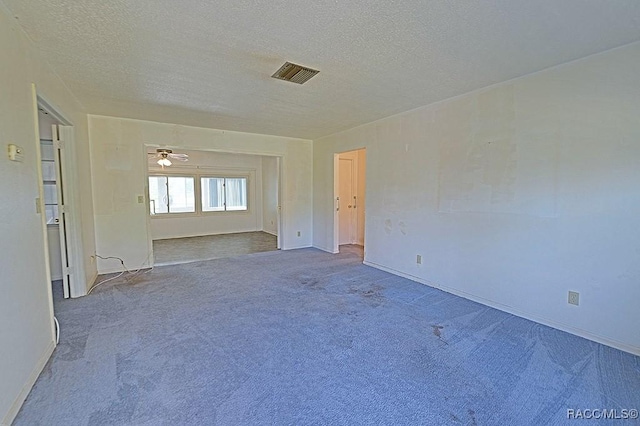 carpeted spare room featuring a textured ceiling and ceiling fan