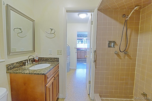 bathroom with vanity, tiled shower, and toilet