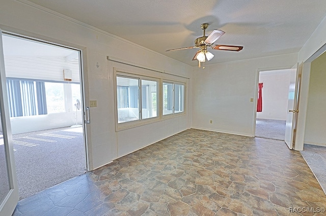 carpeted spare room featuring ceiling fan, a textured ceiling, and ornamental molding