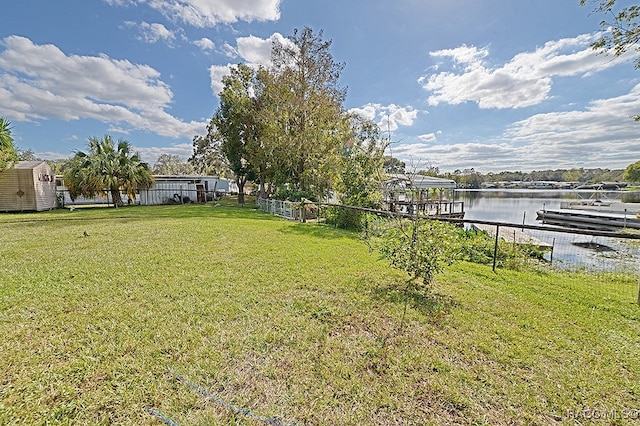 view of yard with a boat dock and a water view