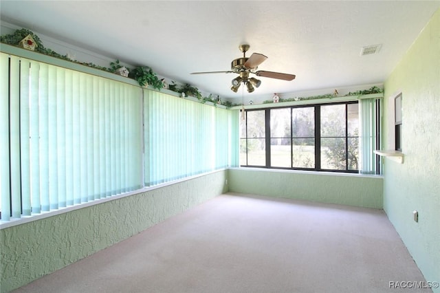 unfurnished sunroom featuring a ceiling fan and visible vents