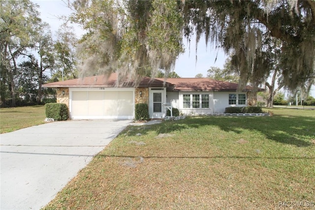 single story home with stone siding, an attached garage, a front lawn, and concrete driveway